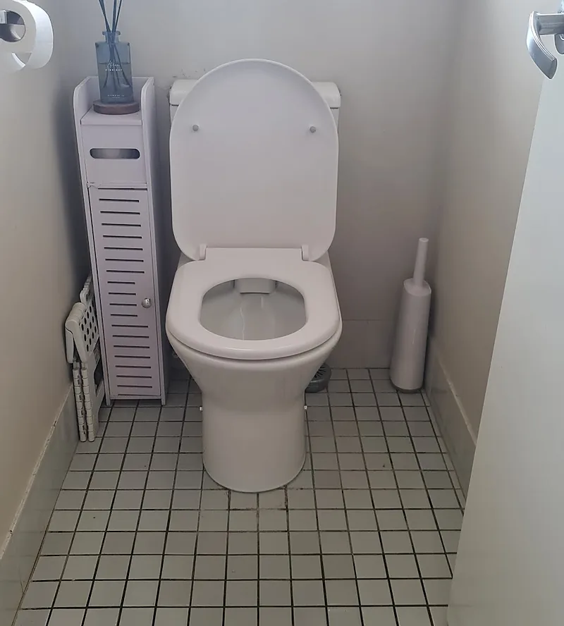A new white close-coupled toilet suite fitted on a tiled floor